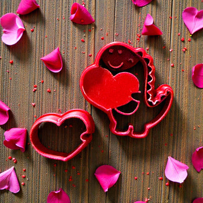 Red dino and heart cutters displayed on wooden background with petals