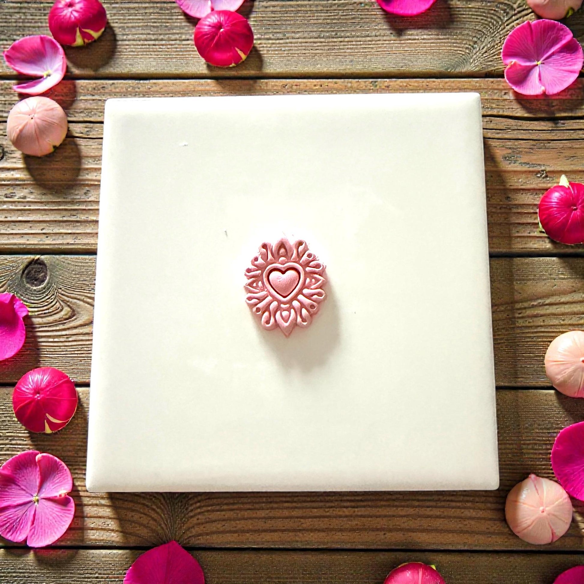 small heart mandala clay shape on white tile