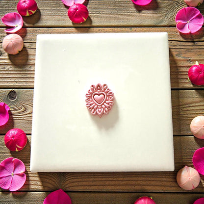 small heart mandala clay shape on white tile