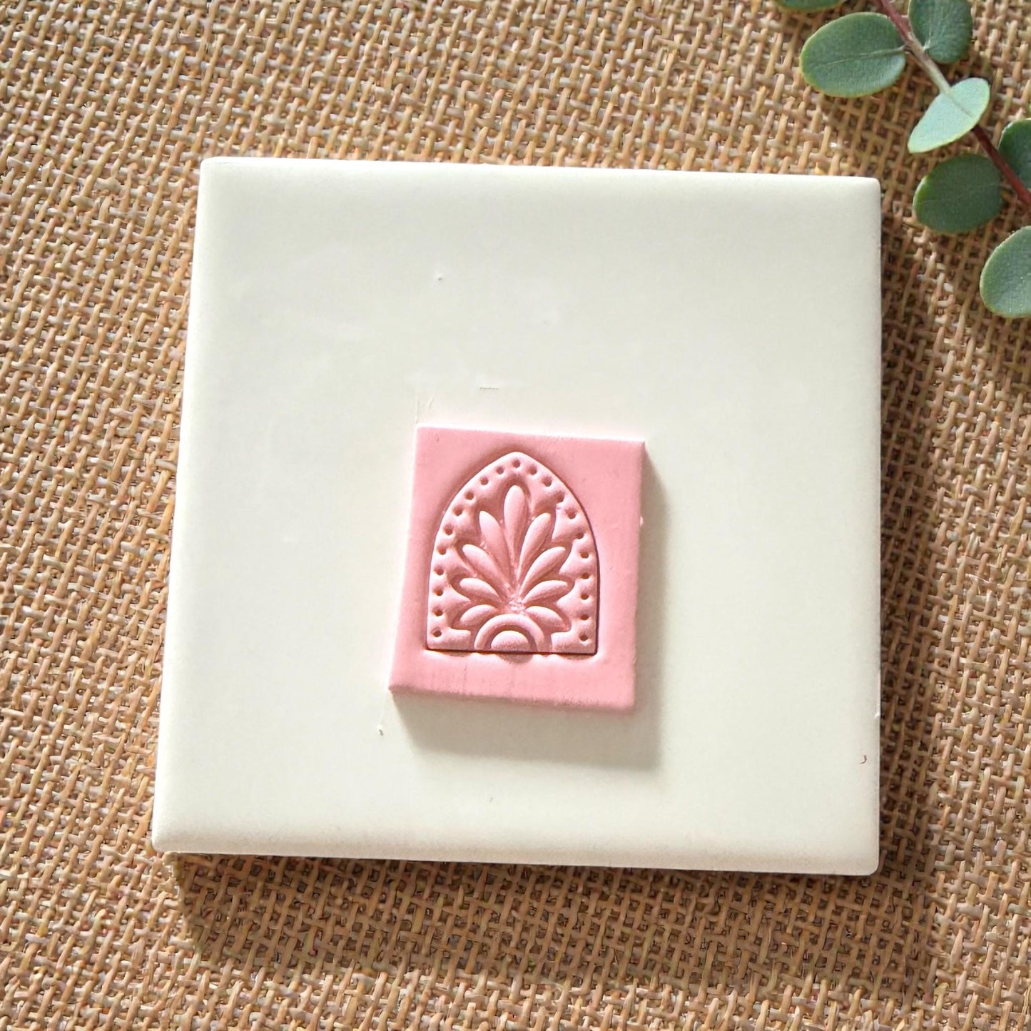 floral arch clay impression centered on pink clay slab