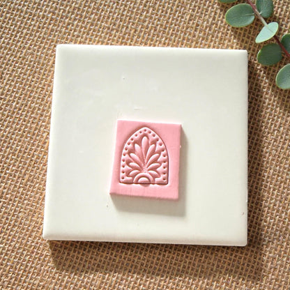floral arch clay impression centered on pink clay slab