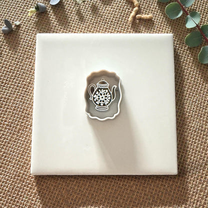 small teapot polymer clay cutter displayed on white tile