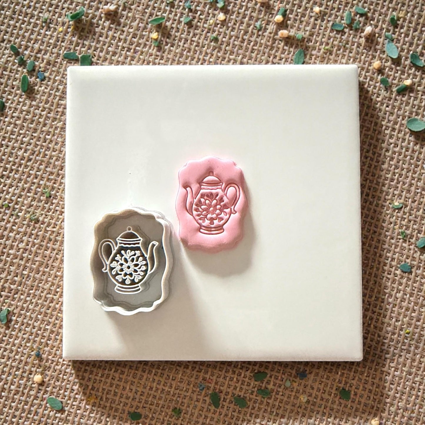 teapot cutter and clay impression on tile with scattered pieces