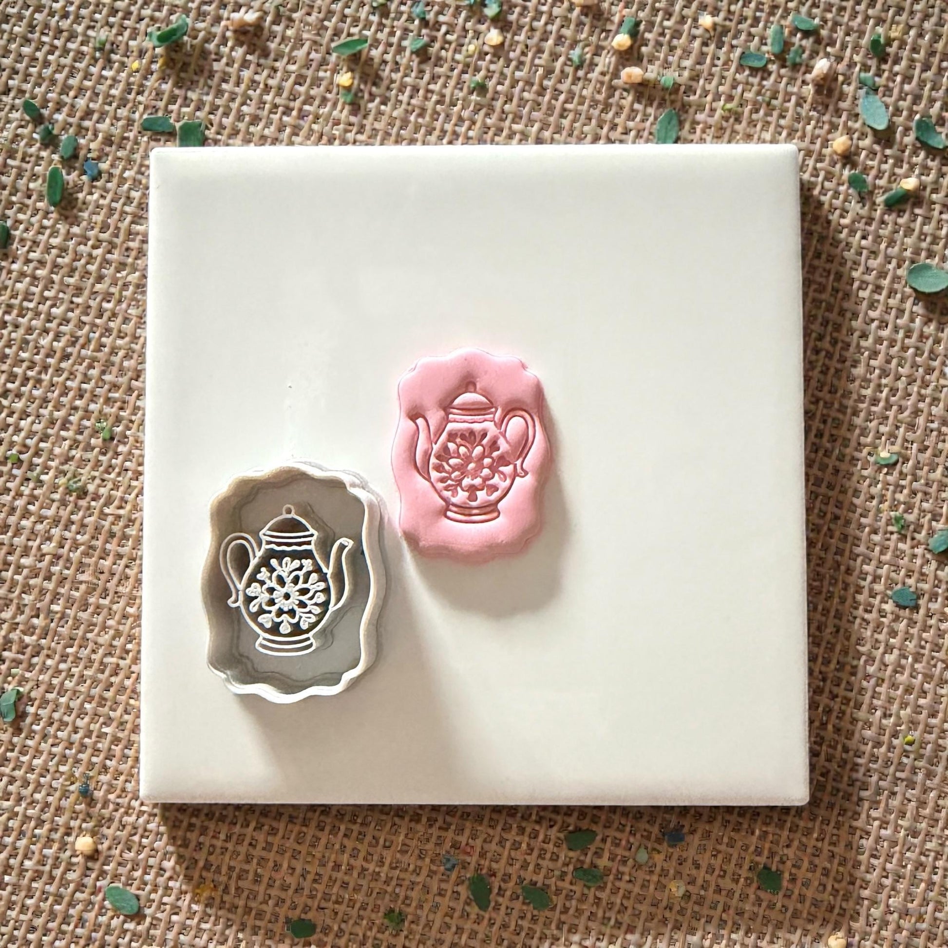 teapot cutter and clay impression on tile with scattered pieces