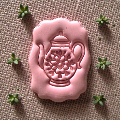 small teapot polymer clay cutter displayed on white tile