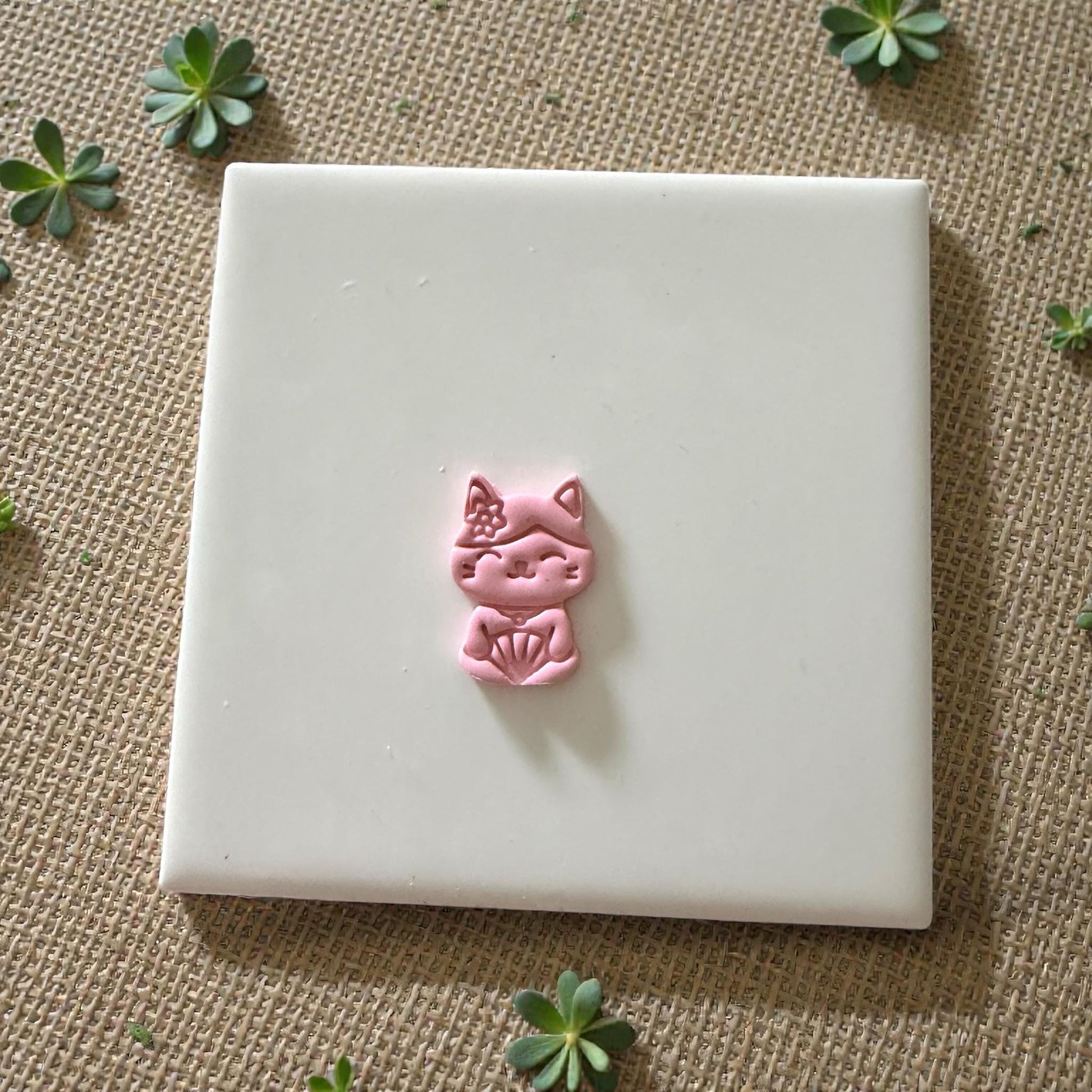 small pink cat clay impression on white tile