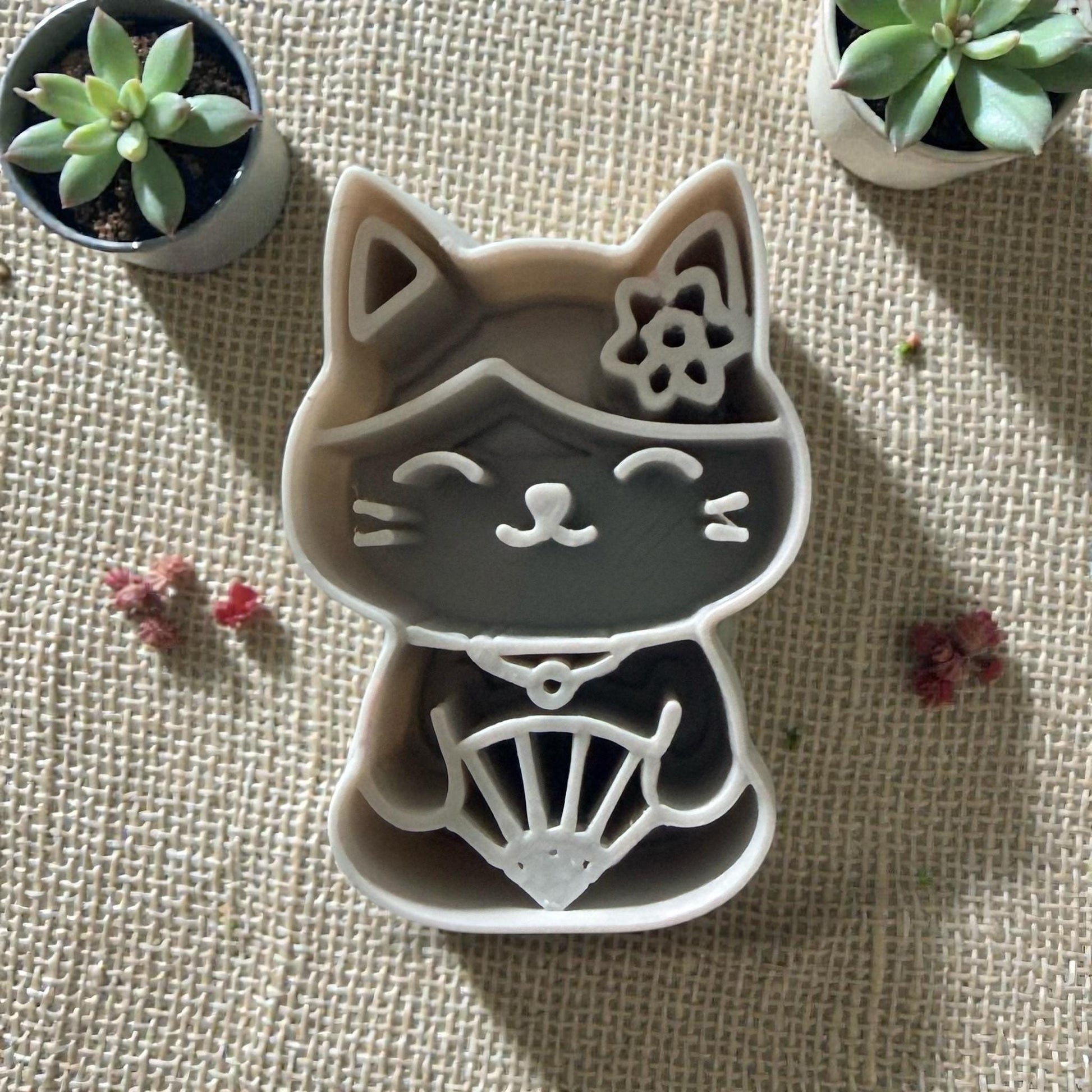 polymer clay cutter kawaii cat with fan detail on burlap background