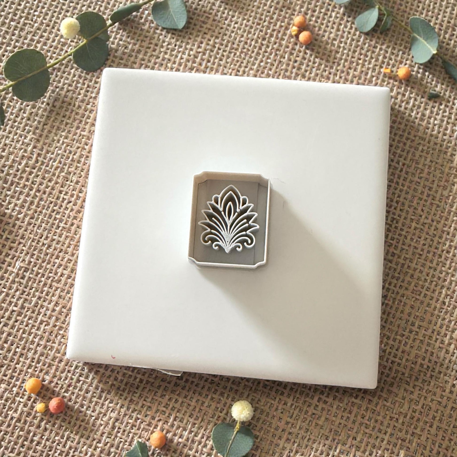 small floral tile clay cutter displayed on white ceramic tile