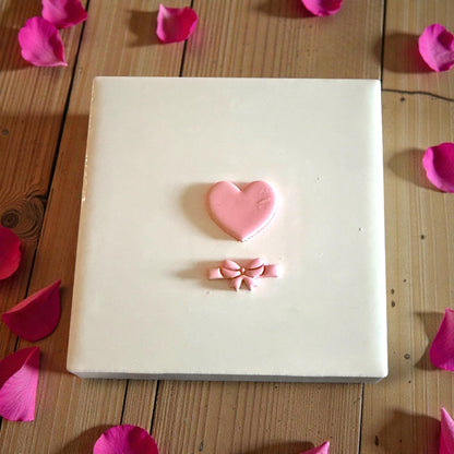 heart and bow clay shapes displayed on white tile