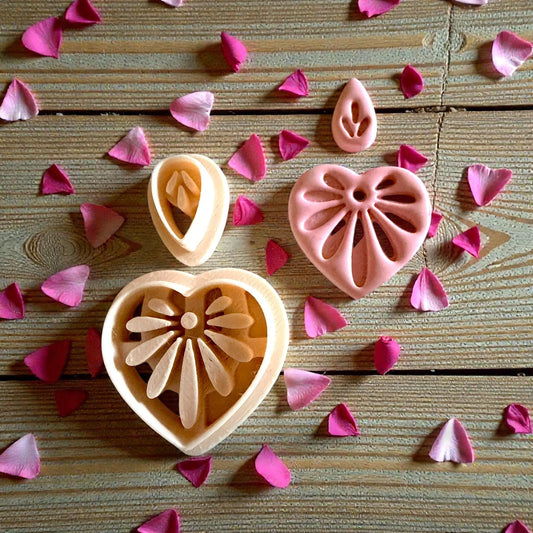 clay cutters and heart floral clay pieces on wood with petals
