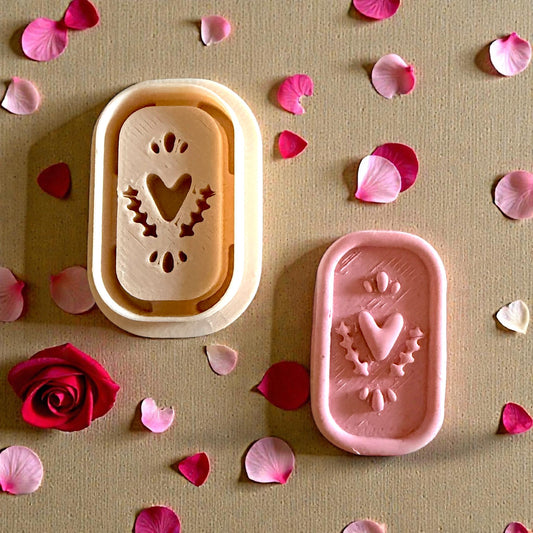 heart plaque and cutter on wood surrounded by petals