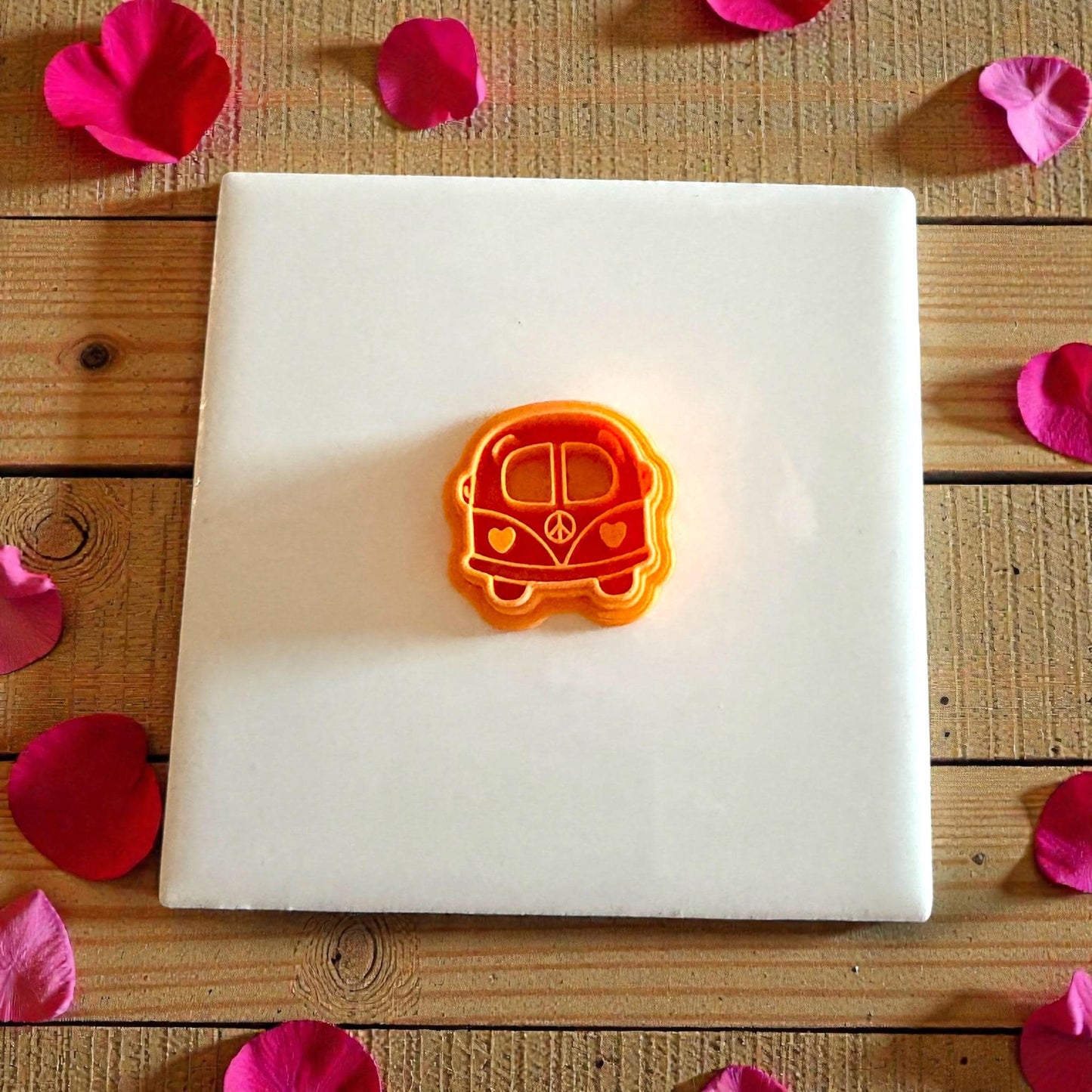 orange love bus cutter centered on white tile