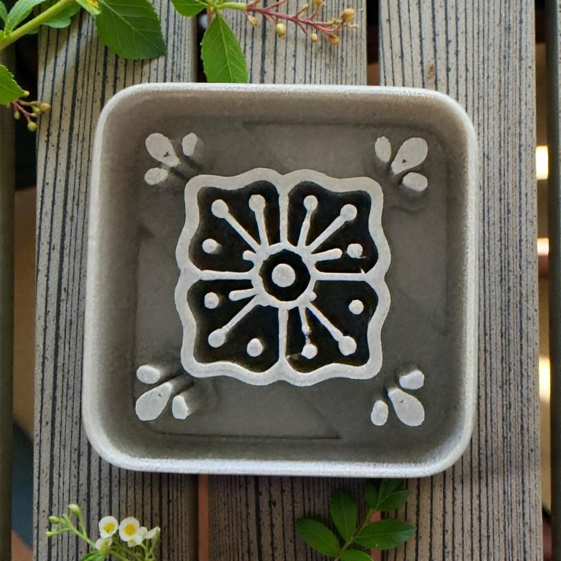 close up of grey square tile cutter on white tile