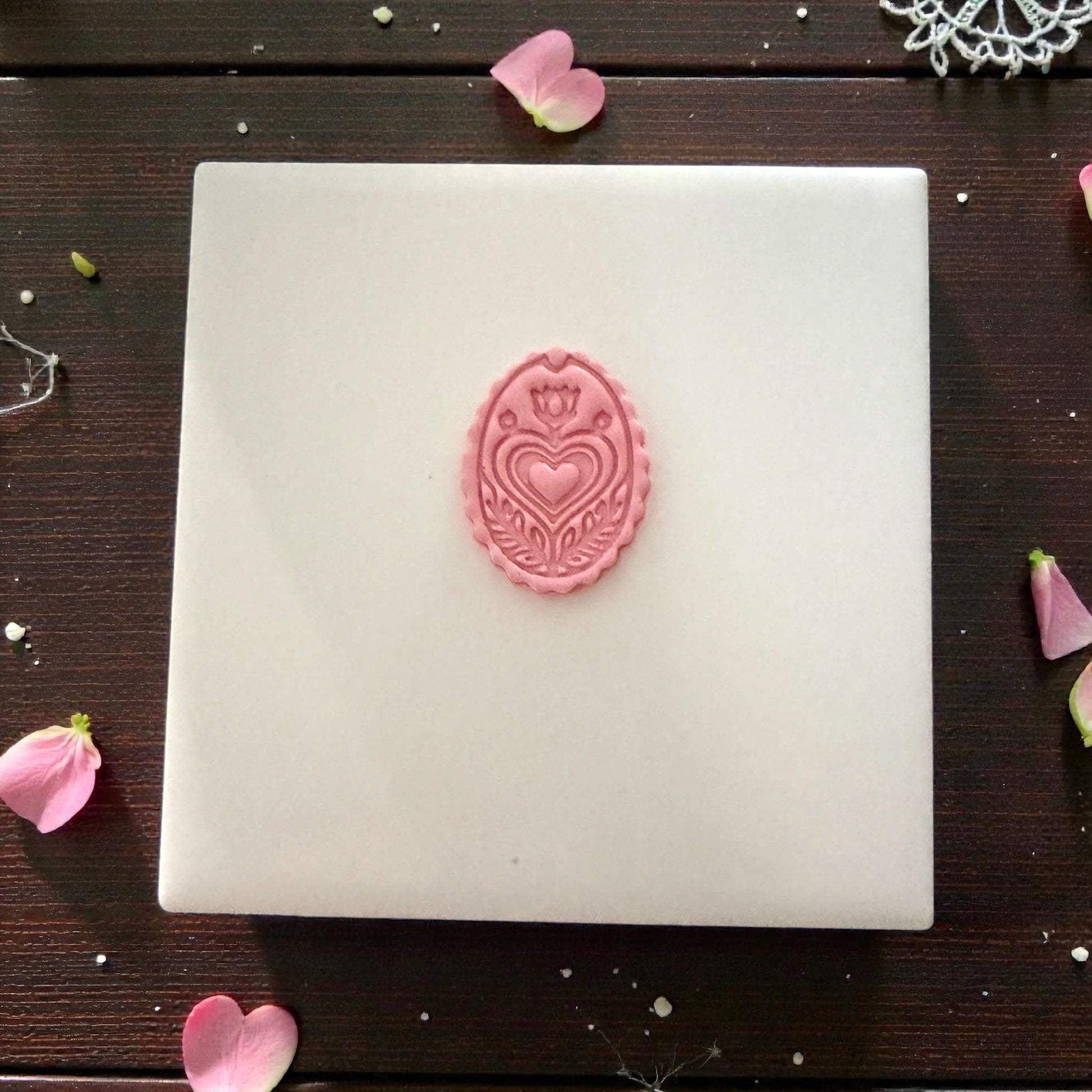 small pink folk heart clay piece centered on tile