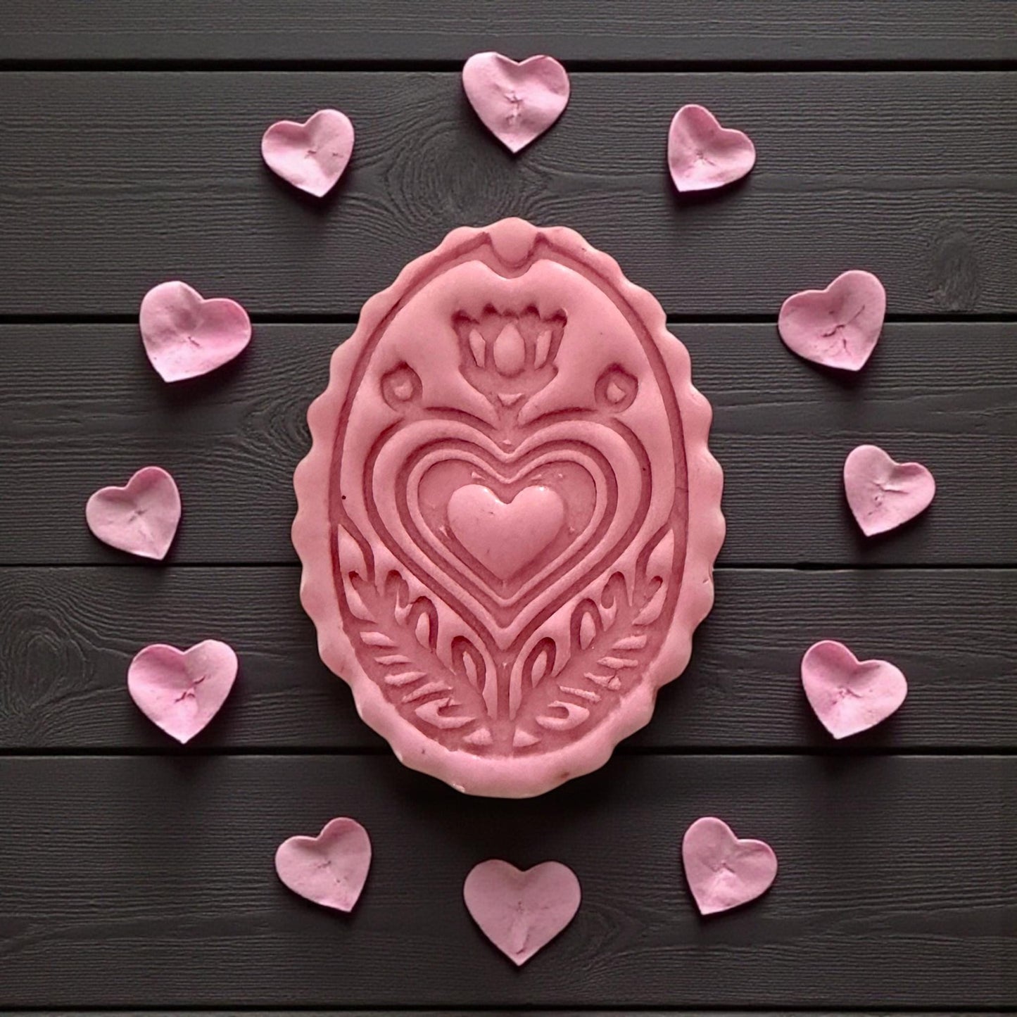 large pink folk oval clay piece surrounded by hearts