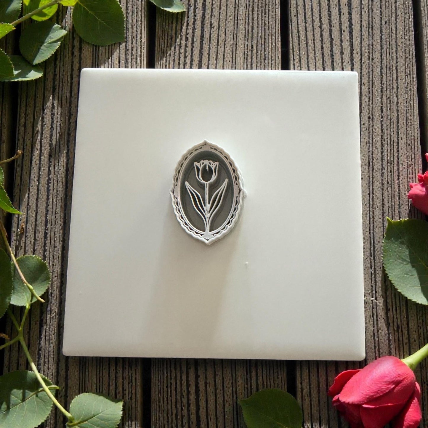 Oval tulip cameo polymer clay cutter on wood background with leaves