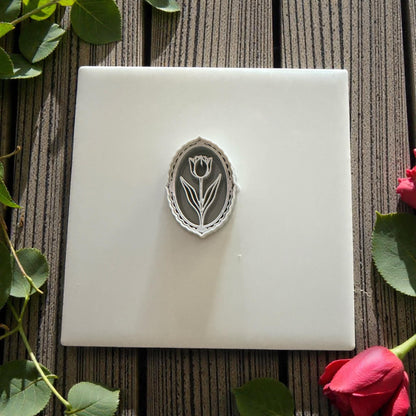 Oval tulip cameo polymer clay cutter on wood background with leaves