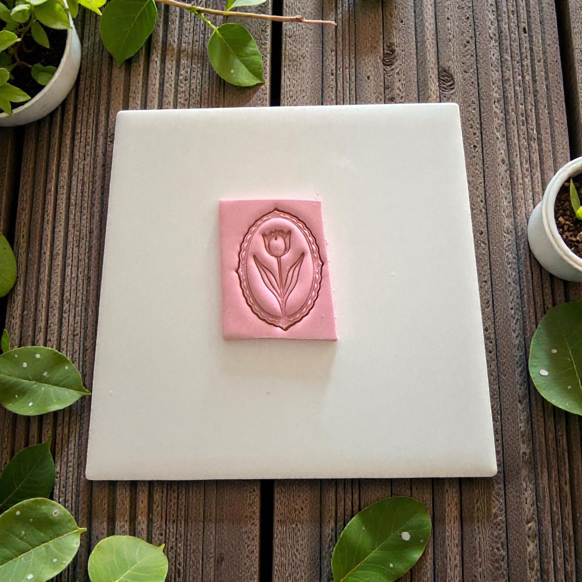 Rectangular clay slab with tulip cameo impression centered on tile