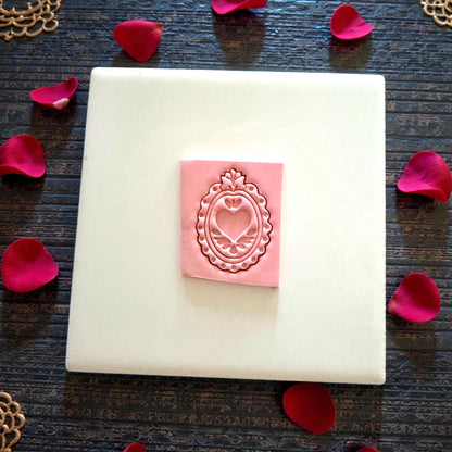 pink clay heart-frame imprint on tile with rose petals