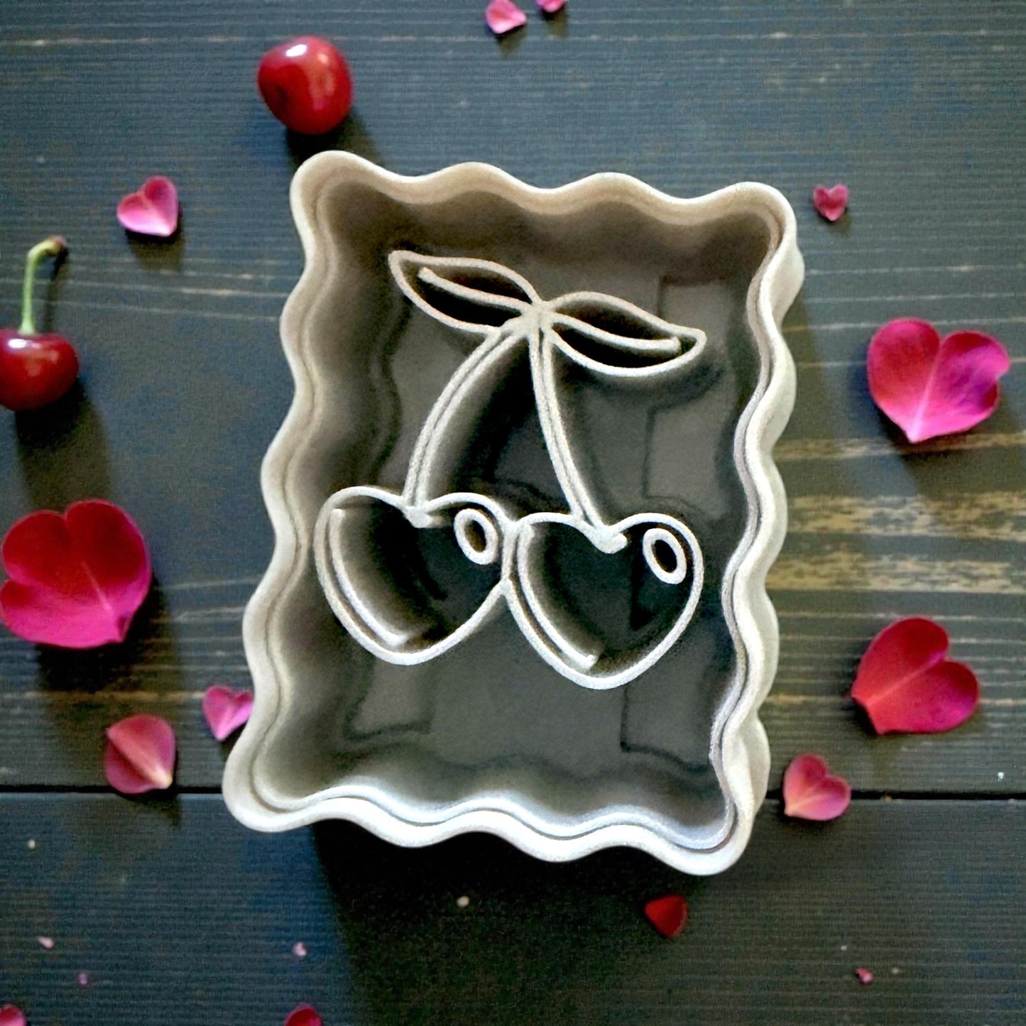 close up of cherry cutter on tile with rose petals