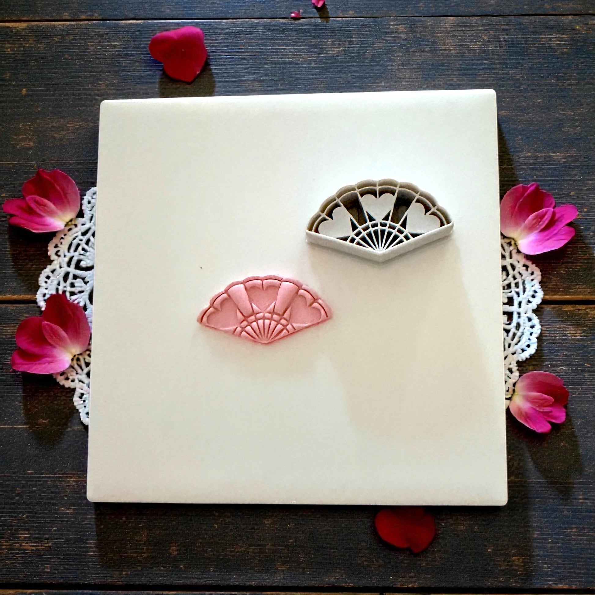 heart fan polymer clay cutter on white tile with lace and pink petals