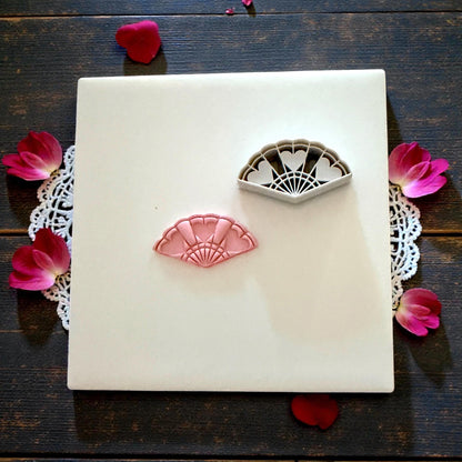 heart fan polymer clay cutter on white tile with lace and pink petals