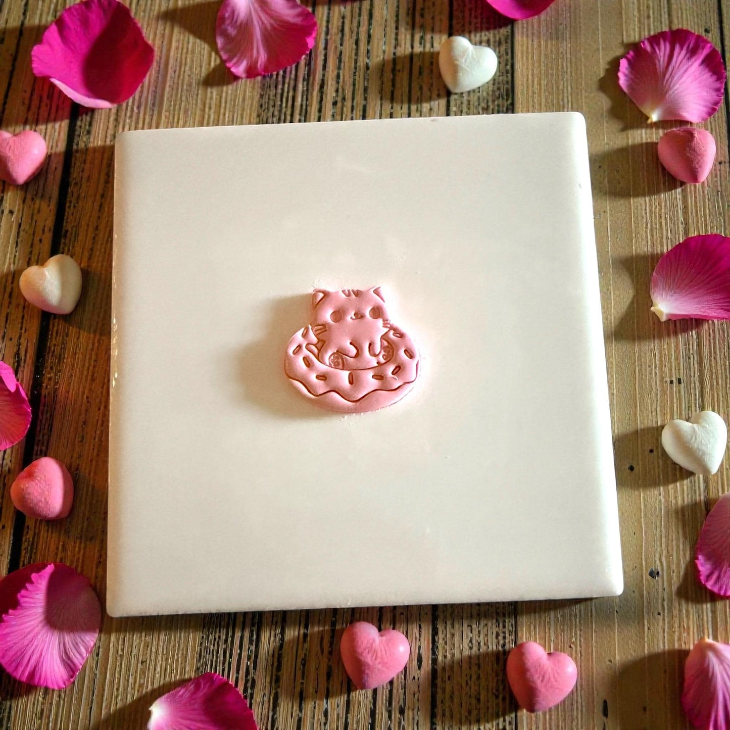 small clay kitty donut shape centered on tile
