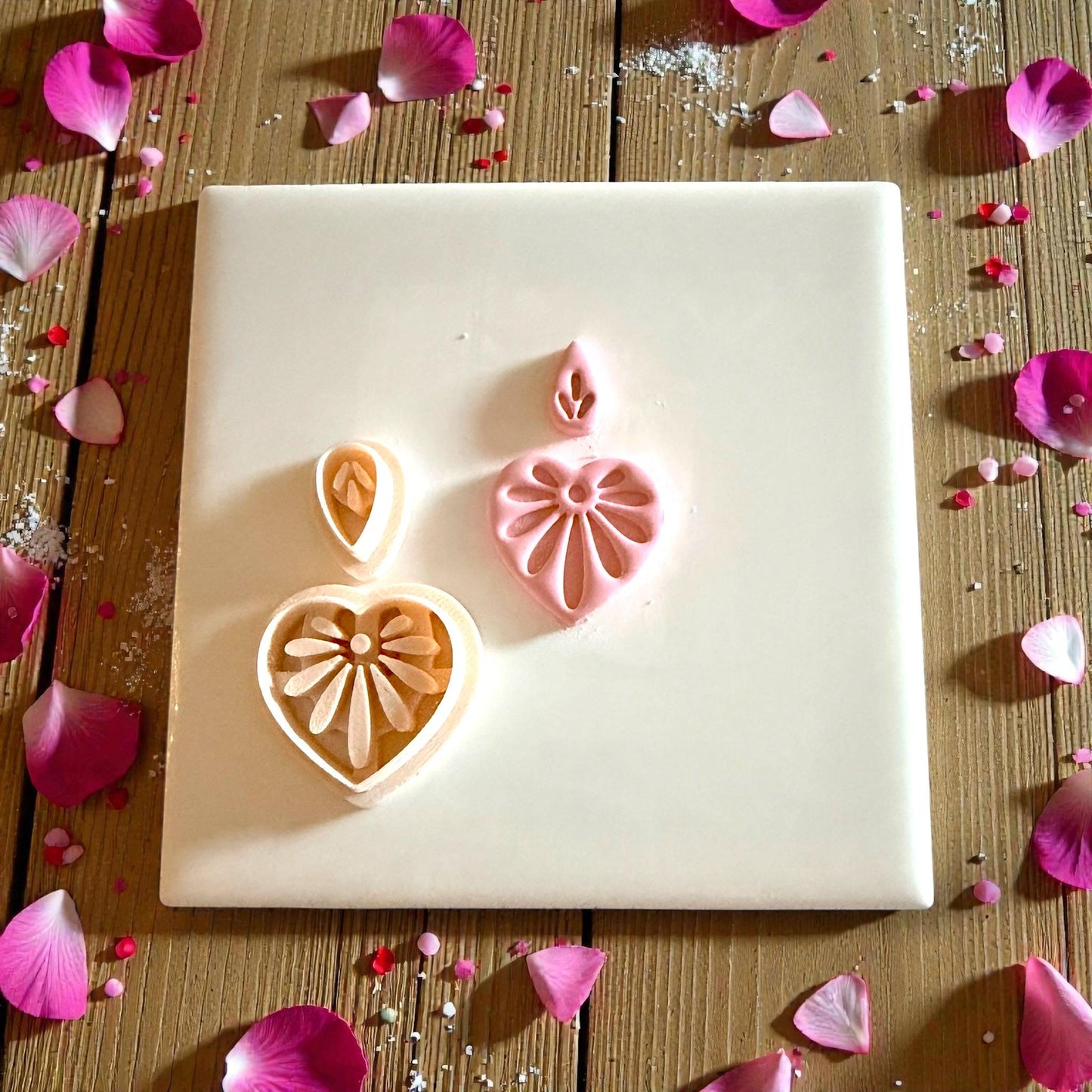 heart floral clay piece next to cutter on white tile
