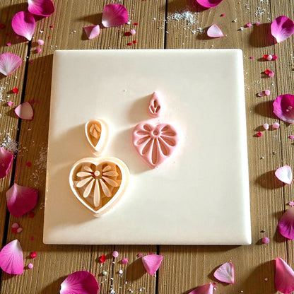 heart floral clay piece next to cutter on white tile