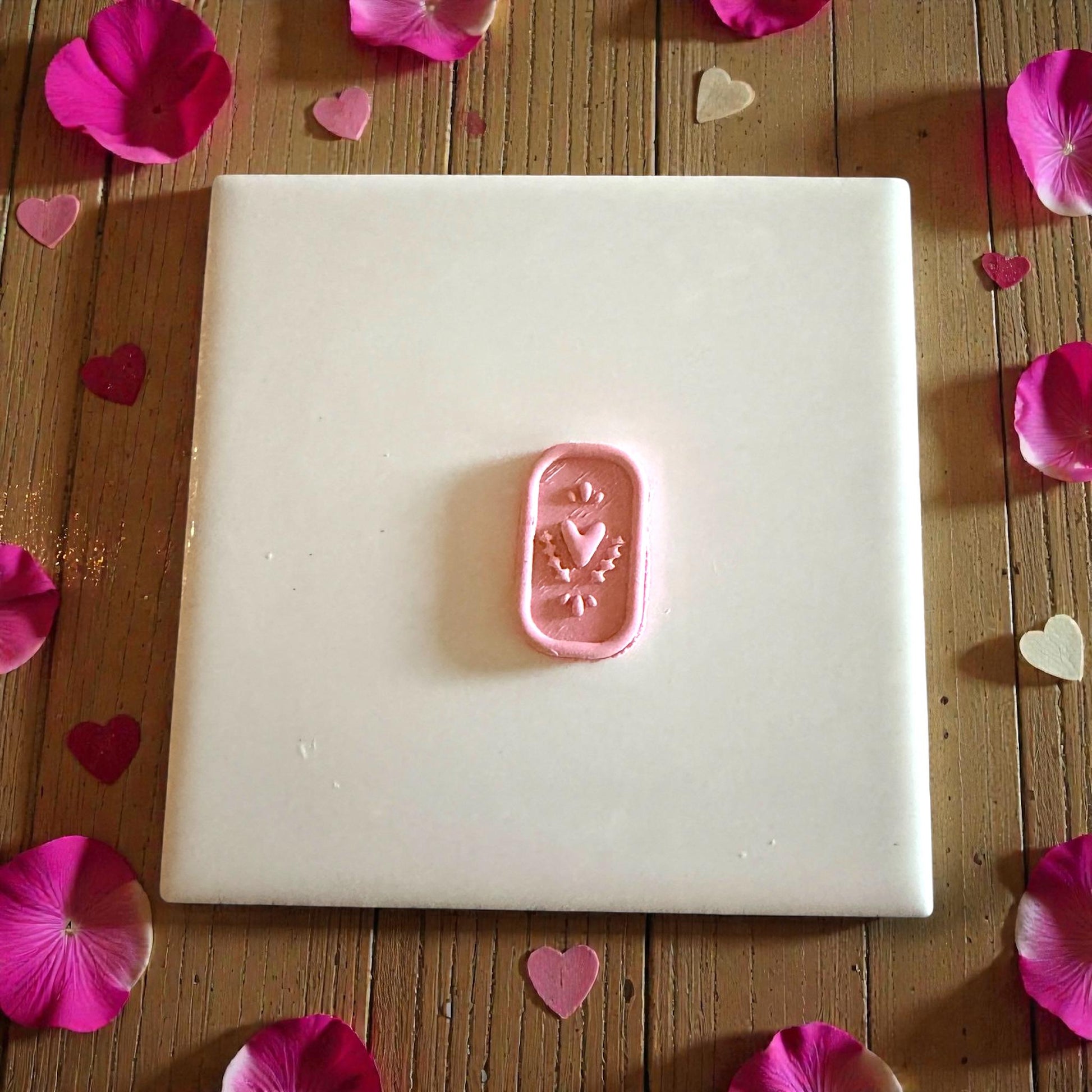 small heart plaque clay piece centered on white tile
