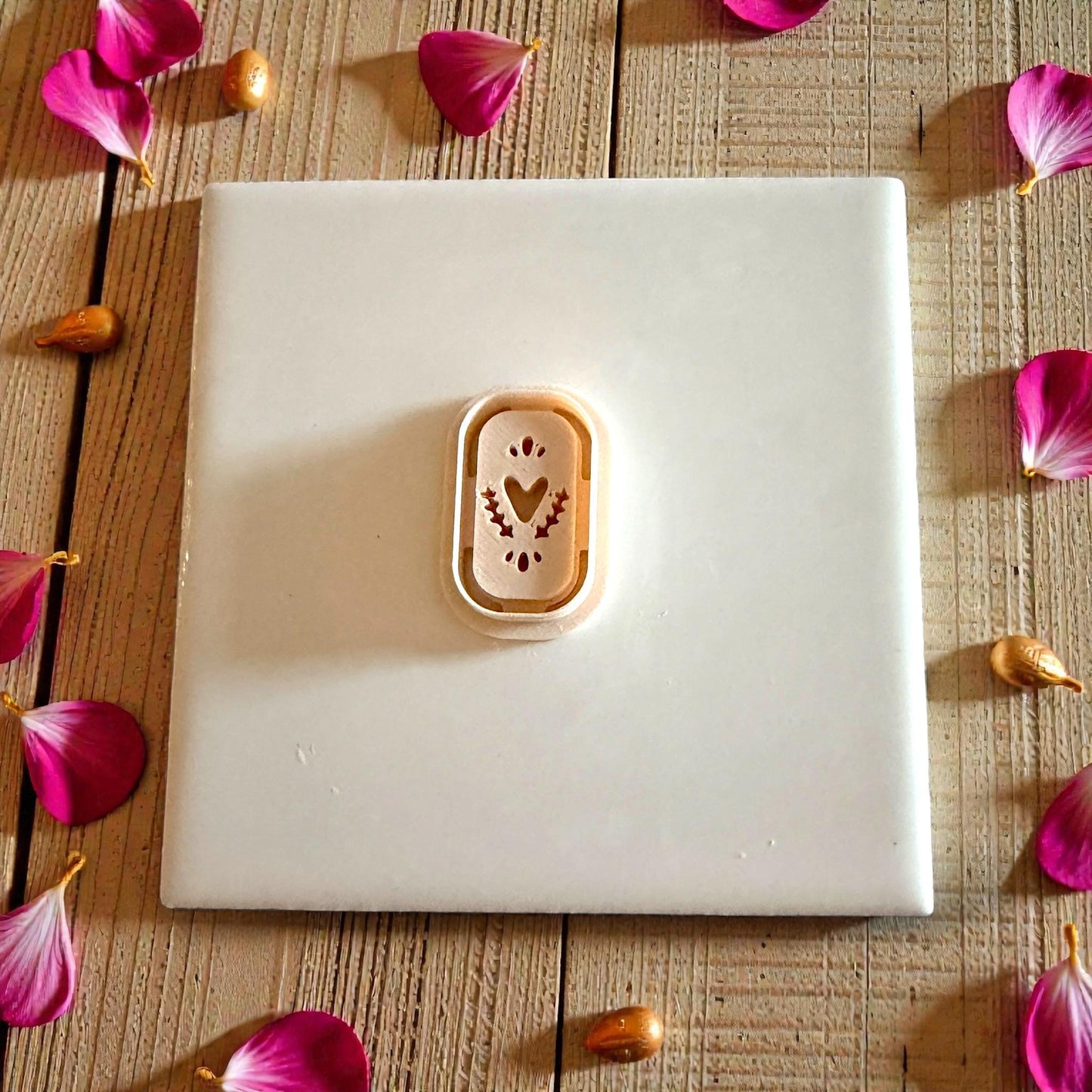 tan cutter on white tile with scattered petals