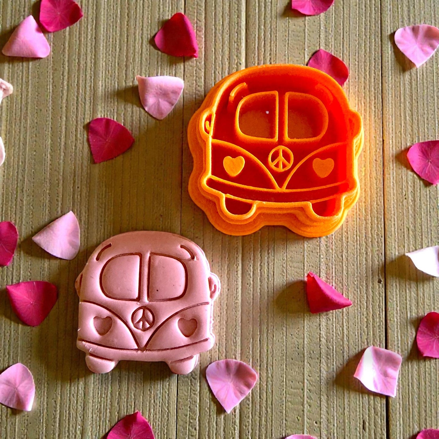 orange cutter and pink love bus clay piece close together