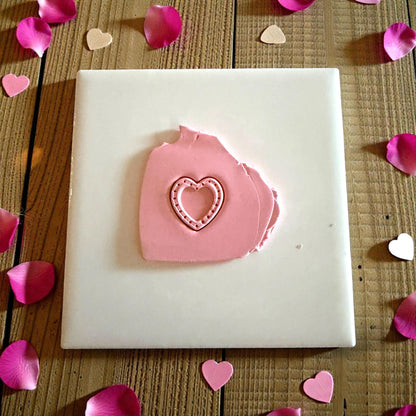 pink dotted heart clay impression on white tile