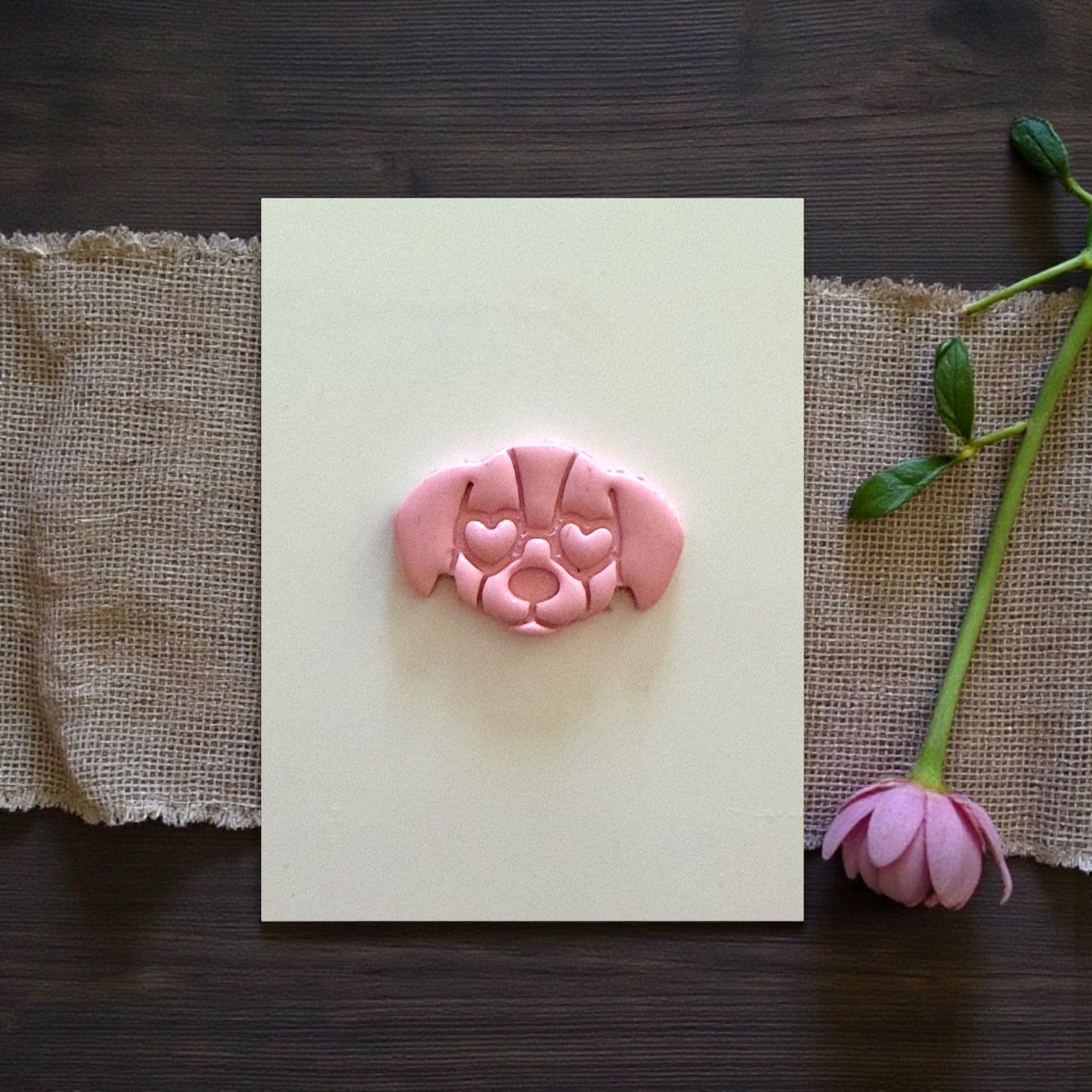 puppy face clay charm centered on tile with flower