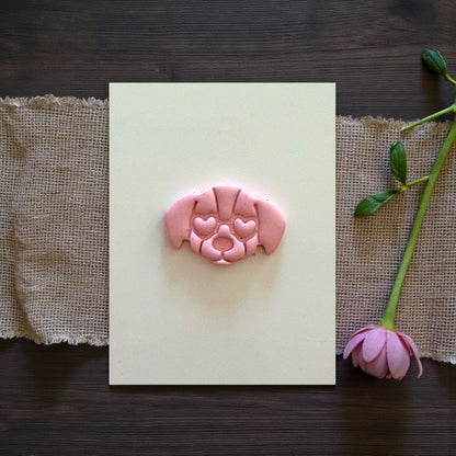 puppy face clay charm centered on tile with flower