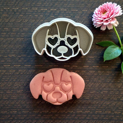 puppy cutter next to clay impression on dark wood