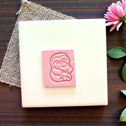 sloth polymer clay imprint on pink clay square