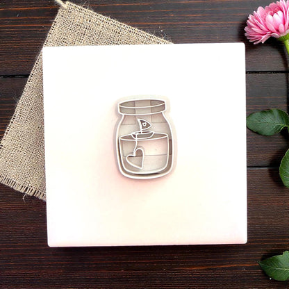 Candle jar polymer clay cutter centered on white tile