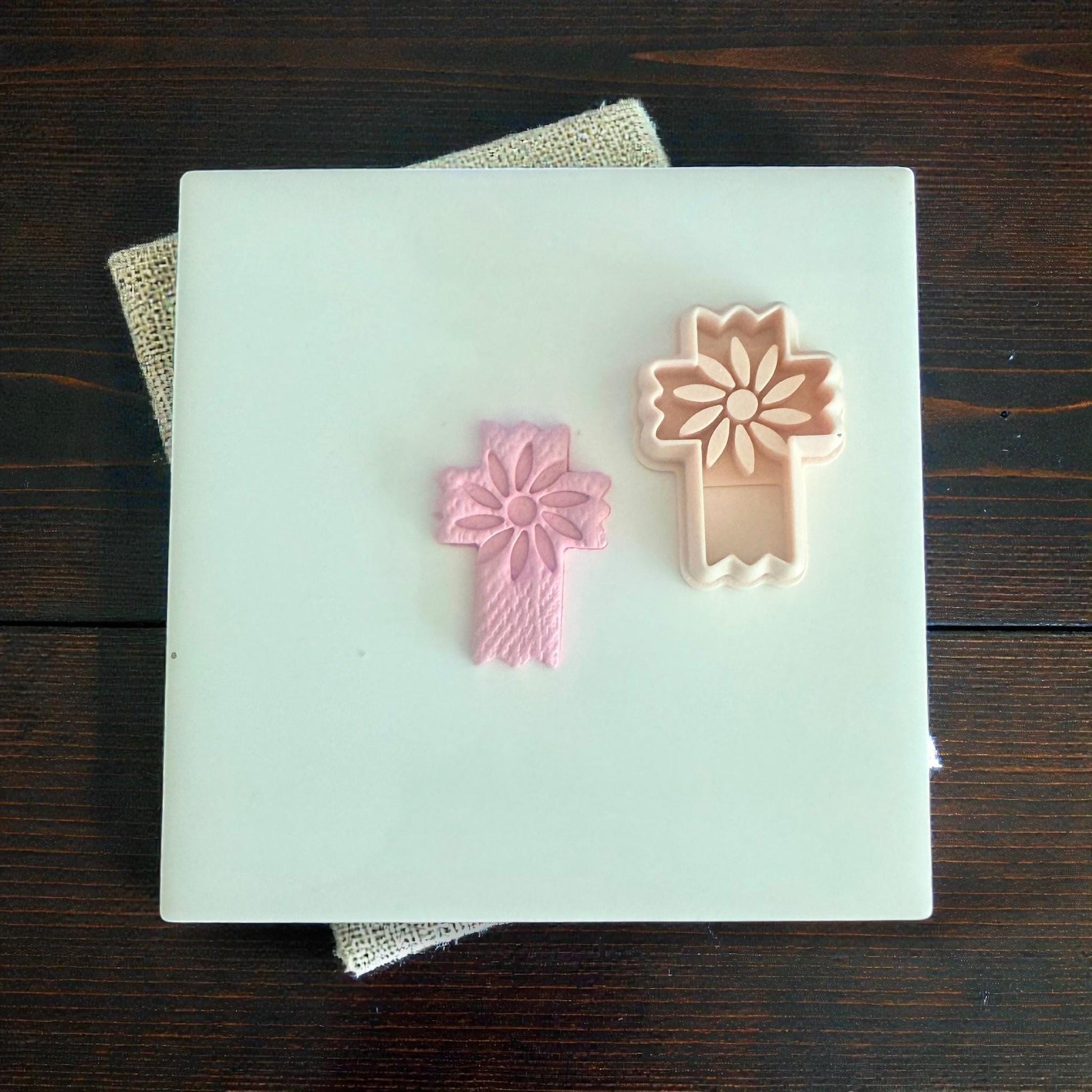 floral cross clay imprint beside matching cutter