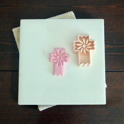 floral cross clay imprint beside matching cutter