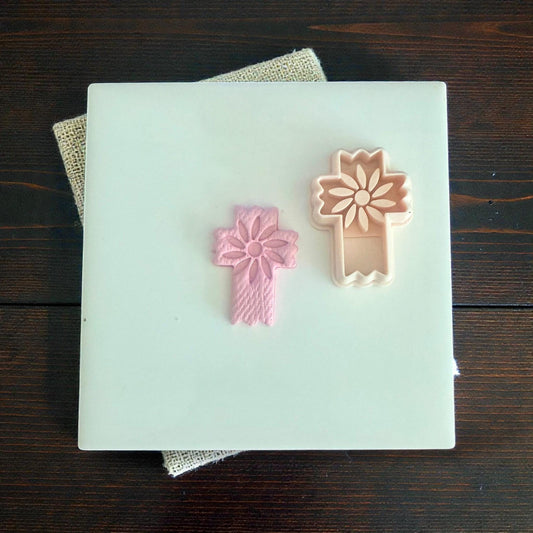 floral cross clay imprint beside matching cutter