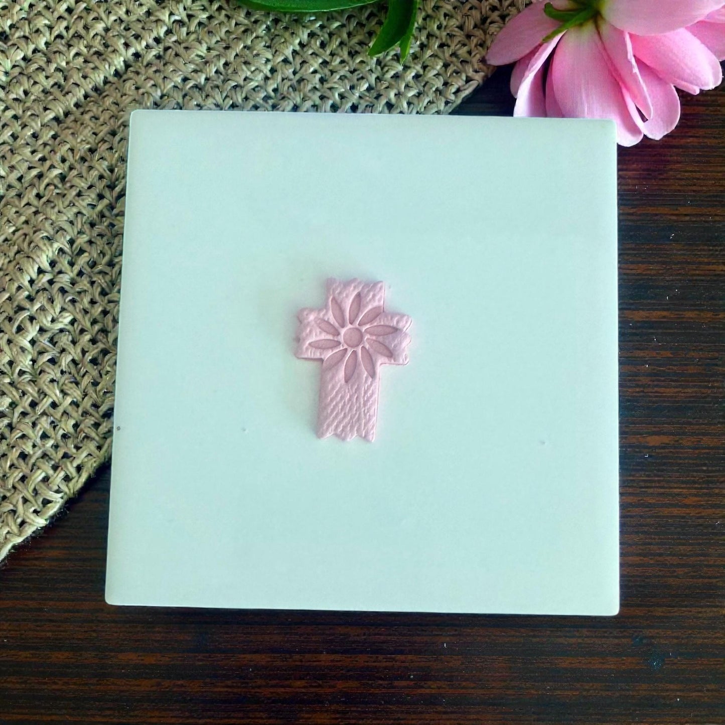 floral cross clay design centered on tile with flowers