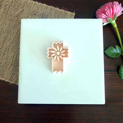floral cross cutter displayed on white tile