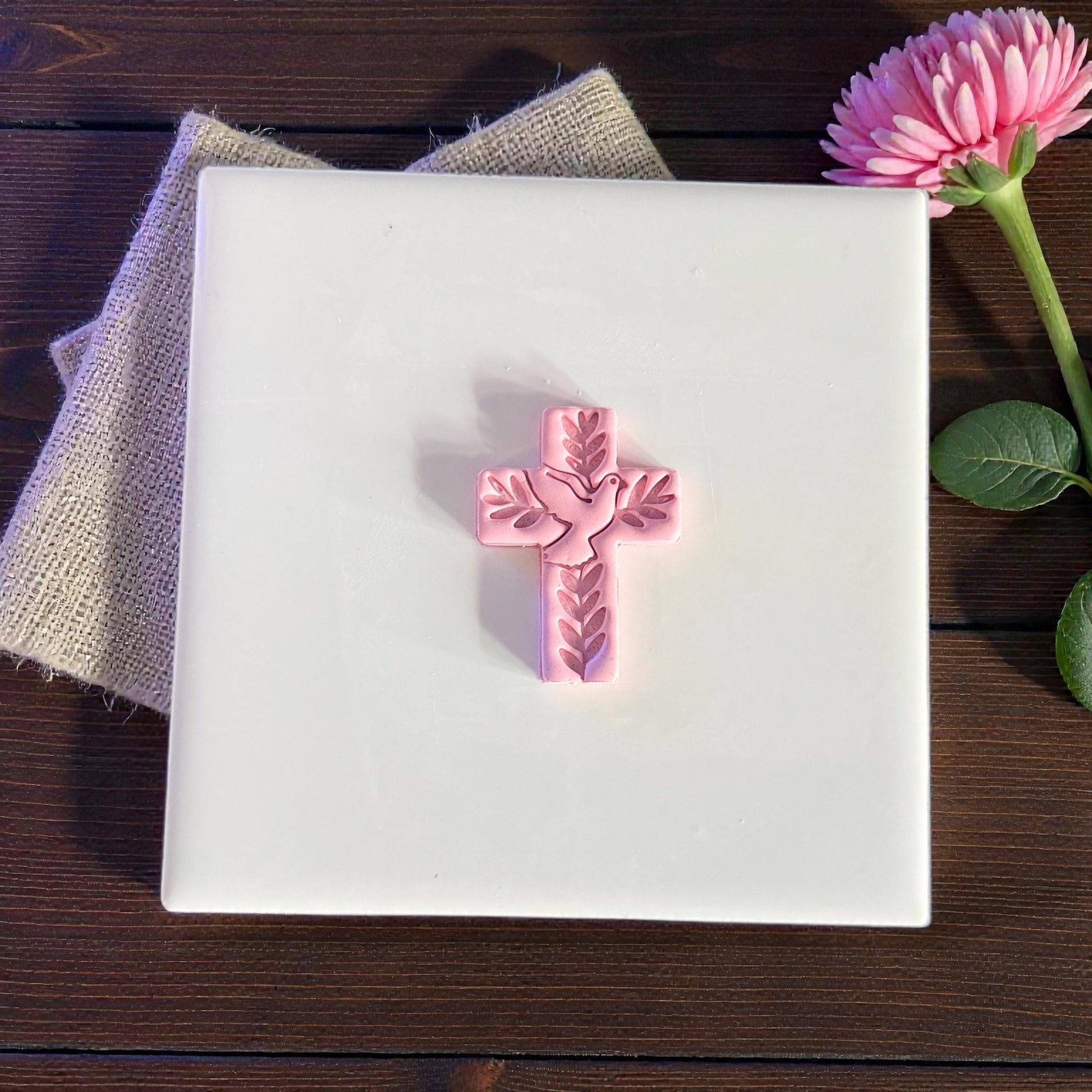 small dove cross clay imprint on white tile
