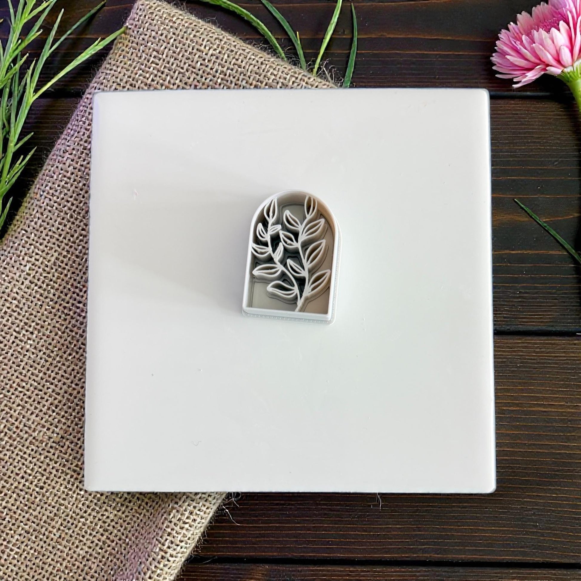 gray botanical arch cutter on white tile