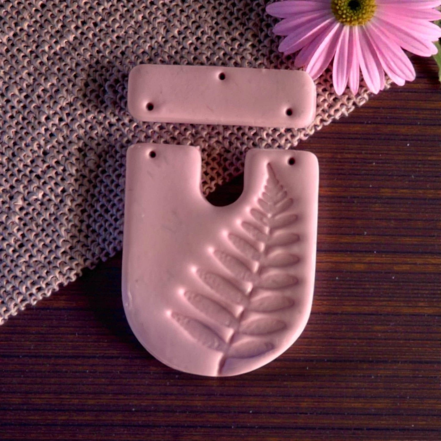 Close-up of pink clay fern U-shape with bar topper