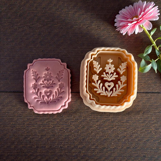 pink clay floral plaque next to matching cutter set on table