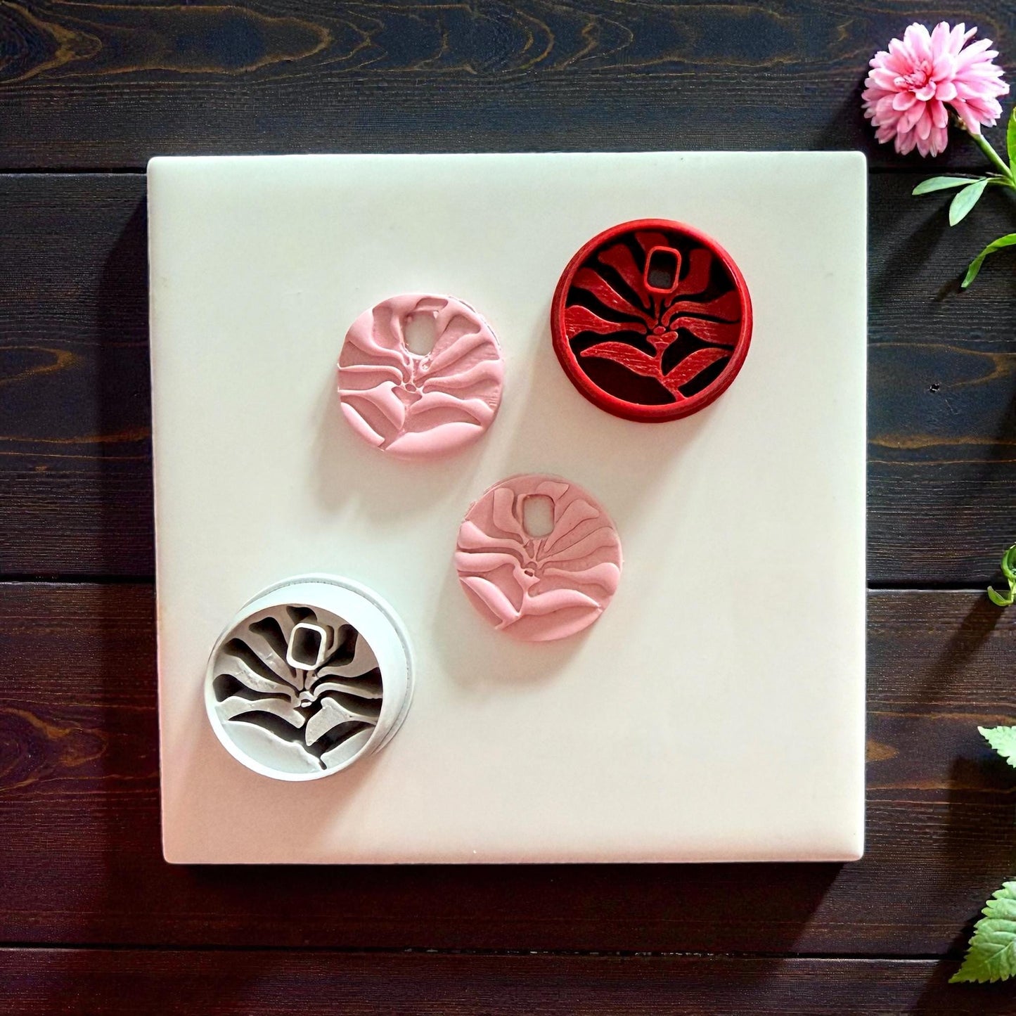 matisse flower charms and cutters arranged on white tile