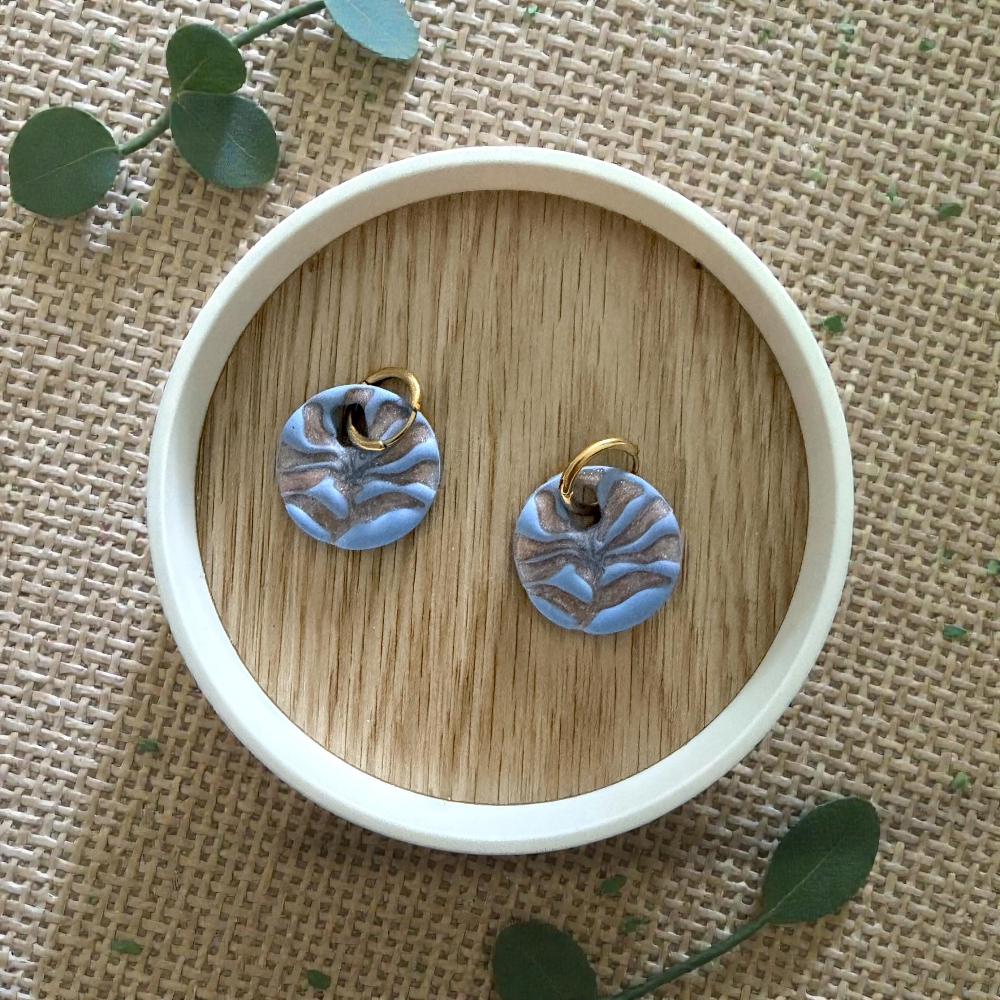 blue and gold matisse flower huggies on white dish