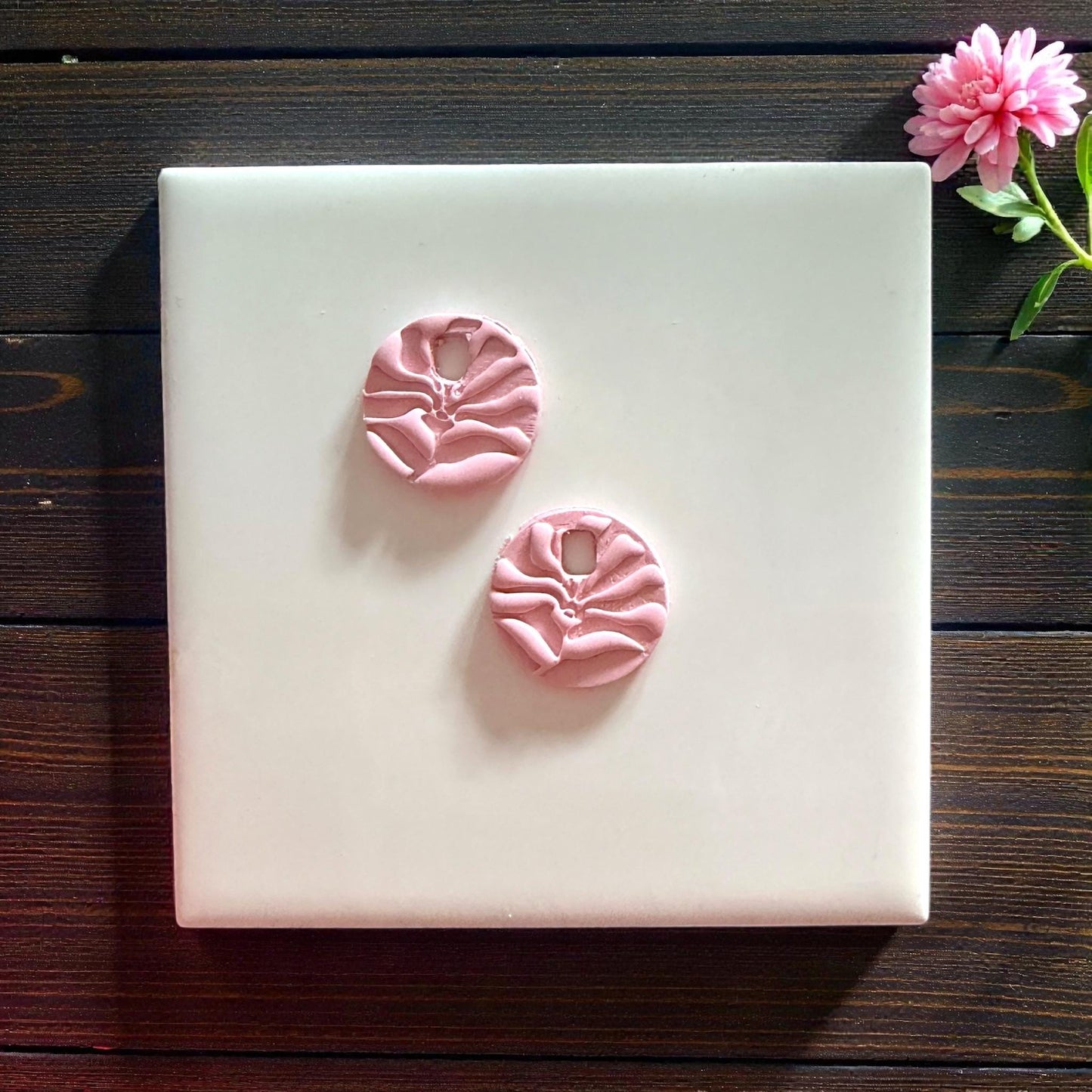 pink matisse flower clay charms displayed on white tiletwo pink matisse flower charms centered on white tile